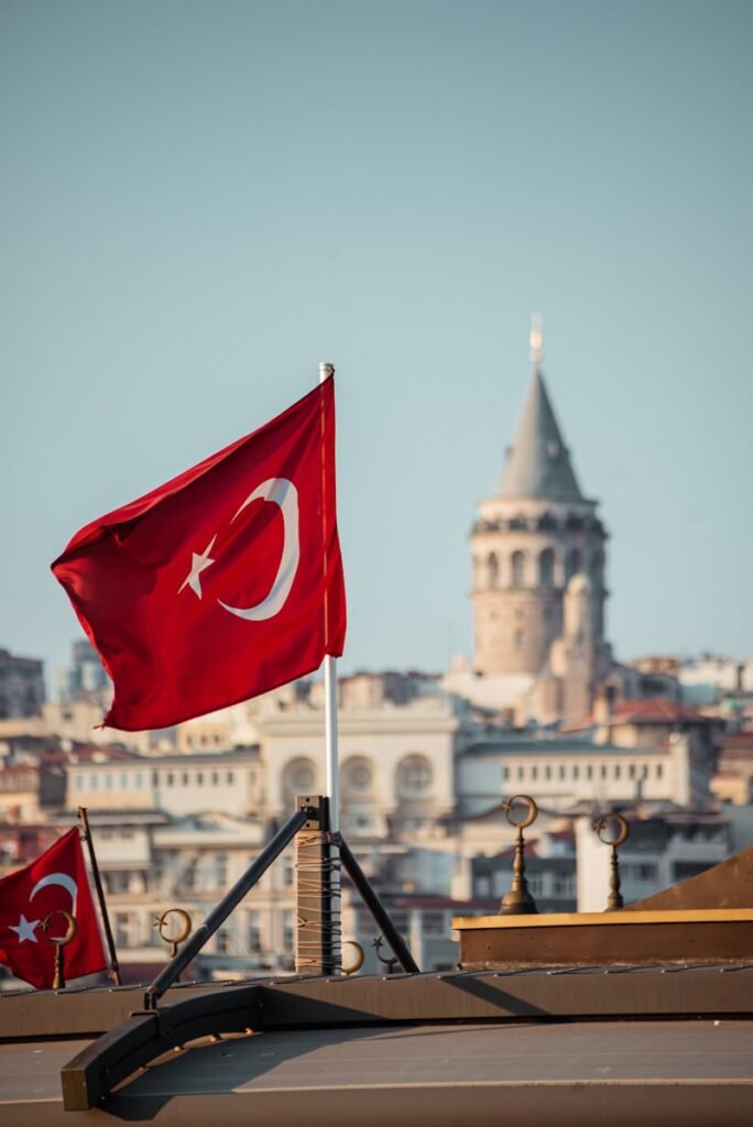 two flags flying in front of a city skyline